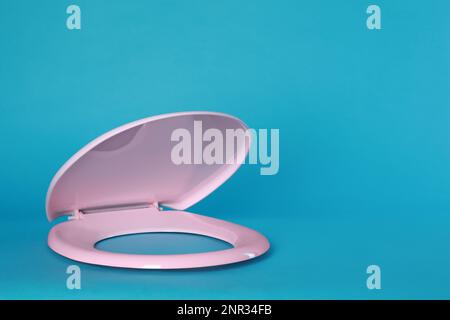Nuovo sedile in plastica rosa su sfondo azzurro, spazio per il testo Foto Stock