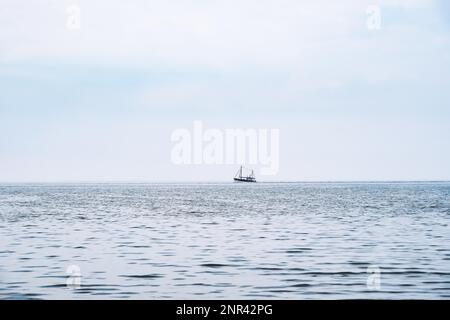 Gamberi distanti imbarcazione all'orizzonte, il mare del Nord in Germania Foto Stock