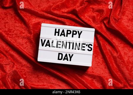 Felice il giorno di san valentino - testo su lightbox o scatola di luce segno sul velluto rosso sfondo Foto Stock