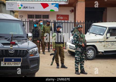 Srinagar, India. 25th Feb, 2023. I soldati paramilitari indiani stanno in guardia presso il sito di attacco in cui Sanjay Sharma a Kashmiri la guardia di sicurezza della banca indù è stata uccise da sospettati militanti a Pulwama Sud del Kashmir amministrato dagli indiani. La polizia ha detto che i militanti sospetti hanno aperto il fuoco su Sanjay Sharma mentre era sulla sua strada verso un mercato locale nel distretto di Pulwama del villaggio di Achan. (Foto di Faisal Bashir/SOPA Images/Sipa USA) Credit: Sipa USA/Alamy Live News Foto Stock