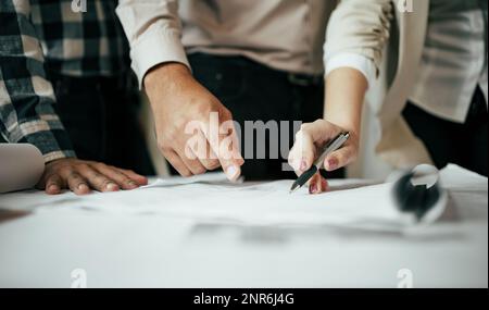 Team di architetti e ingegneri che lavorano e discutono del nuovo progetto di startup sulla scrivania. L'architetto discute con il tecnico del progetto in ufficio. Foto Stock