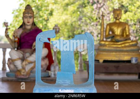 Una sedia di plastica rotta in un tempio buddista, Thailandia Foto Stock