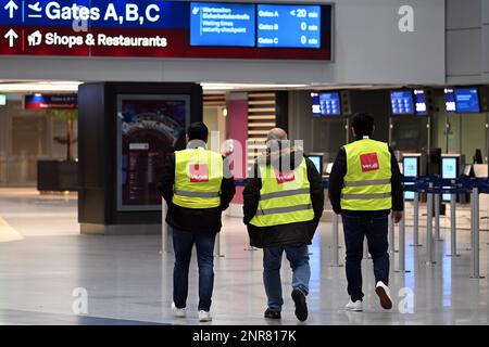 Duesseldorf, Germania. 27th Feb, 2023. Gli uomini di Verdi vesti a piedi attraverso l'aeroporto di Düsseldorf. Il sindacato Verdi ha invitato i suoi membri ad effettuare scioperi di allarme negli aeroporti della Renania settentrionale-Vestfalia e nel settore pubblico. Credit: Federico Gambarini/dpa/Alamy Live News Foto Stock