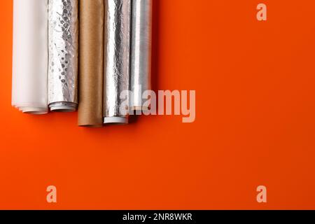 Rotoli di alluminio, carta da forno e pellicola alimentare su sfondo colorato Foto Stock