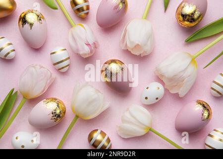 Uova d'oro di Pasqua e tulipani rosa su sfondo rosa. Vista dall'alto. Buona composizione pasquale. Foto Stock