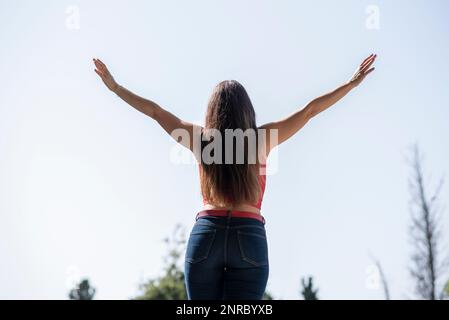 Vista posteriore di donna felice con le braccia distese Foto Stock