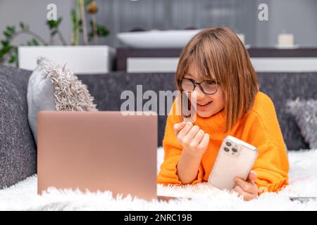 il bambino si rallegra del successo davanti allo schermo del notebook Foto Stock