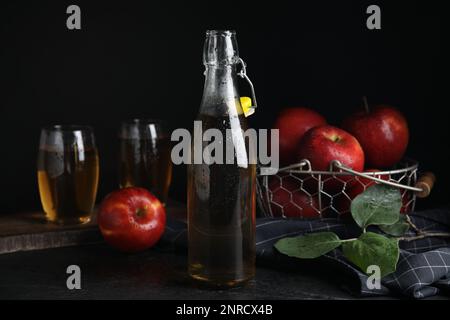 Composizione con delizioso sidro di mela su tavola nera Foto Stock