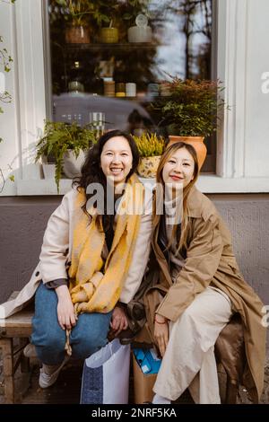 Ritratto di felici amici donne seduti insieme sulla panchina Foto Stock