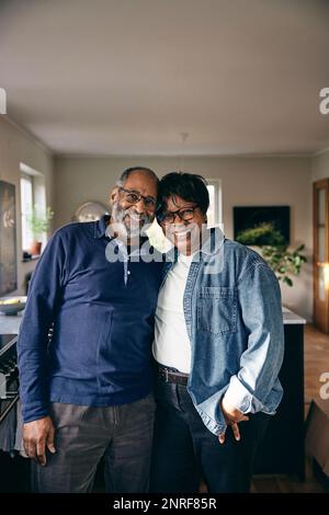 Ritratto di coppia anziana sorridente in piedi l'una con l'altra a casa Foto Stock