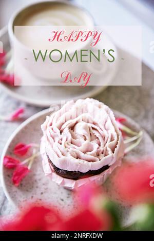 Cupcake rosa estetico con fiori e testo Happy Womens Day. Foto verticale. Foto Stock