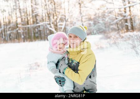Un uomo di 35-40 anni ha una figlia di un anno in inverno Foto Stock