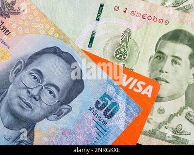 Dettaglio macro con una banconota da 50 baht thailandese e una carta di credito o di debito per il visto. Il baht è la valuta ufficiale della Thailandia Foto Stock