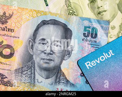 Dettaglio macro con una banconota da 50 baht thailandese e una carta di credito o di debito revolut. Il baht è la valuta ufficiale della Thailandia Foto Stock