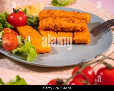 bastoncini di pesce, gustosi frutti di mare, croccanti filetti di pesce fritti serviti con insalata e pomodori. Fast food. Foto Stock