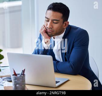 Vorrei che accadesse qualcosa di eccitante. un giovane uomo d'affari che guarda annoiato al lavoro. Foto Stock