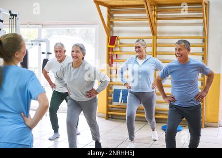 Gruppo di persone anziane felici che ballano e allenano in classe di fitness di casa di cura Foto Stock