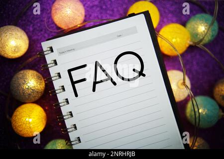 Messaggio di testo FAQ (Frequently Asked Questions) sullo sfondo del blocco note Foto Stock