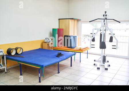 Interno del centro di riabilitazione con letto e attrezzature sportive in camera Foto Stock