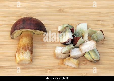 Metà e fette di funghi commestibili Imleria badia, comunemente conosciuta come baie bolete. I pori e la carne macchiano da blu opaco a grigio-bluastro quando sono ammaccati o tagliati. Frutta Foto Stock