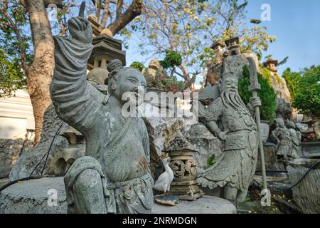 Statue cinesi di pietra portate dalla Cina come zavorra sulle navi che consegnano riso in Cina, in un piccolo giardino a Wat Suthat (tempio) Bangkok, Thailandia Foto Stock