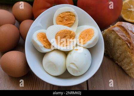 uova di pollo bollite molto fresche, con un tuorlo rotondo giallo o arancione e un bianco ben formato. uovo su un tavolo di legno Foto Stock