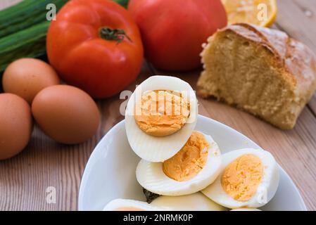 uova di pollo bollite molto fresche, con un tuorlo rotondo giallo o arancione e un bianco ben formato. uovo su un tavolo di legno Foto Stock
