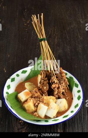 Sate Padang, Padang Beef Satay con Ketupat o Lontong in torta di riso compresso. Su tavola di legno Foto Stock