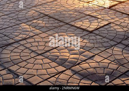 Le lastre di pavimentazione si trovano inesattamente sotto le onde del sole su una strada nella città della Russia Foto Stock