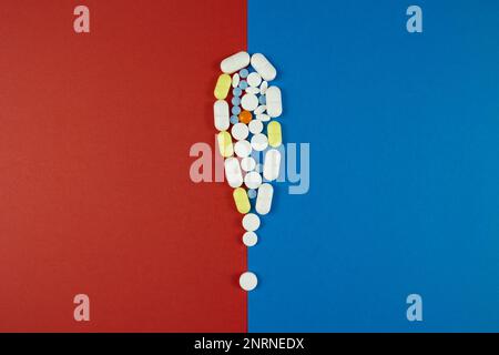 Pillole o farmaci 'effetti collaterali foto concetto. Segnale di avvertimento realizzato con pillole isolate su sfondo blu e rosso. Foto Stock