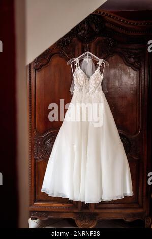 armadio della sposa e dello sposo e articoli di abbigliamento abito da sposa matrimonio appeso sullo sfondo della porta di un vecchio armadio di legno Foto Stock