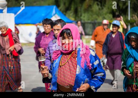 Pellegrino a piedi con la ruota di preghiera nella città di Thimphu. Capitale del Bhutan. Foto Stock
