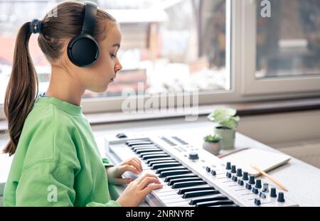 Bambina che impara a suonare il pianoforte a casa, lezione di musica, apprendimento. Foto Stock