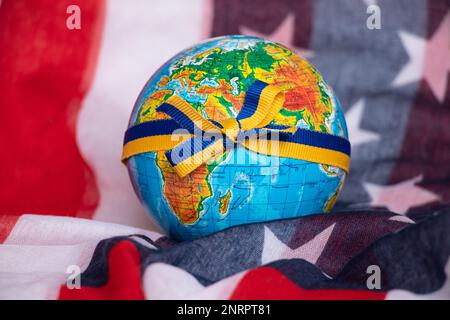 Un globo legato con un nastro con la bandiera dell'Ucraina si trova sulla bandiera dell'America da vicino Foto Stock