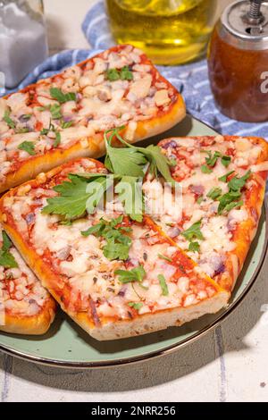 Pizza baguette fatta in casa. Baguette barche. Sandwich di casseruola al forno con pancetta, funghi, pomodori, mozzarella di pollo Foto Stock