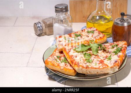 Pizza baguette fatta in casa. Baguette barche. Sandwich di casseruola al forno con pancetta, funghi, pomodori, mozzarella di pollo Foto Stock