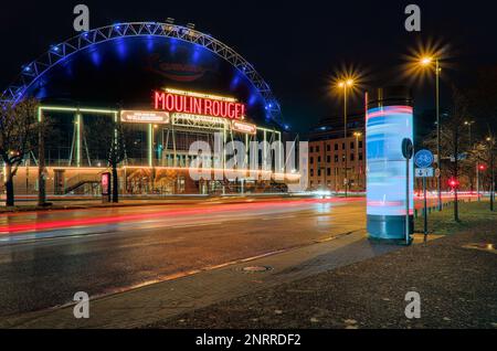 Un vivace e accattivante 'Moulin Rouge! Das Musical' segno di fronte al Musical Dome in un'atmosfera vivace su una strada cittadina di notte Foto Stock