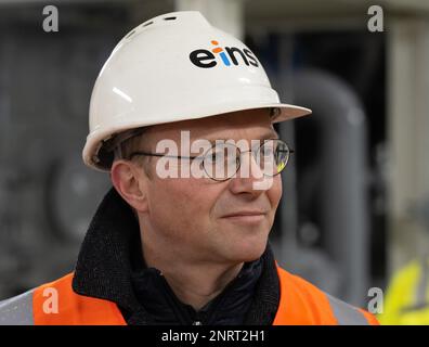 Chemnitz, Germania. 27th Feb, 2023. Wolfram Günther (Verdi), Ministro dell'energia in Sassonia, visita l'impianto di cogenerazione dei motori del fornitore di energia eins energie a Chemnitz. Il motivo della sua visita è di discutere i piani attuali per il cambiamento regionale dell'energia, l'espansione delle energie rinnovabili e la questione del futuro approvvigionamento energetico. Credit: Hendrik Schmidt/dpa/Alamy Live News Foto Stock