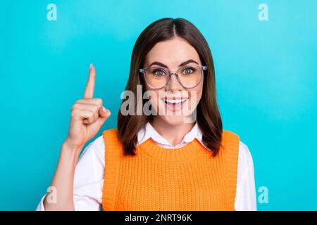 Foto di buon umore divertente carina donna intelligente con pettinatura corpetto arancione sollevare il dito buona idea isolato su sfondo colore teal Foto Stock