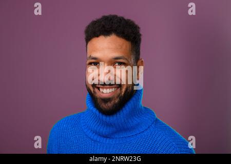 Ritratto di felice uomo multirazziale in maglia maglione. Foto Stock