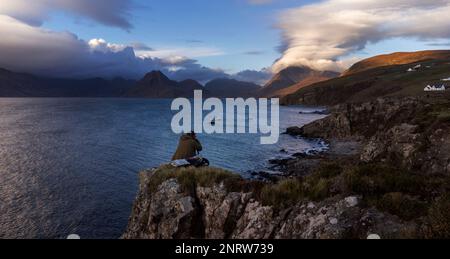 Un fotografo scatta foto guardando verso nord ovest attraverso Loch Scavaig verso la catena montuosa di Cuillin nel villaggio di Elgol sull'isola di Skye. Foto Stock