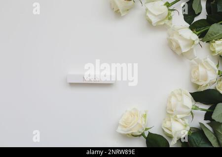 Giornata internazionale della donna. Banner, volantini, cartolina bellissima per l'8 marzo. Composizione dei fiori. Cornice in fiori di rosa freschi bianchi su bianco Foto Stock