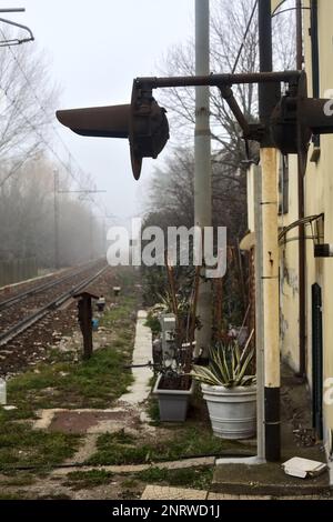 Ferrovia che passa in un parco in una giornata di nebbia Foto Stock