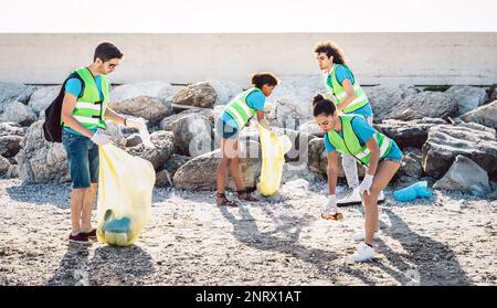 Volontari sociali che indossano uniforme in spiaggia attività di pulizia sulla spazzatura rifiuti - ambiente conservazione concetto per il materiale plastico inquinio Foto Stock