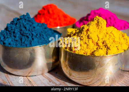 Coloratissimi colori Gulal organici in polvere in ciotole per il festival indiano Holi. Sfondo di legno. Foto di alta qualità Foto Stock