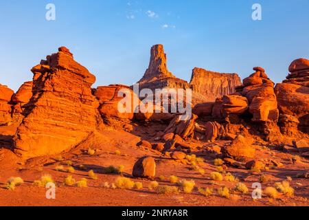 Un butte di arenaria di Wingate con formazioni rocciose di arenaria di Cutler di fronte lungo lo Shafer Trail vicino a Moab, Utah. Foto Stock