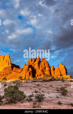 Cielo tempestoso sulle formazioni di arenaria Entrada delle rocce Navajo al tramonto vicino a Moab, Utah. Foto Stock