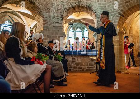 Nijmegen, Paesi Bassi. 21st Feb, 2023. Il falso sacerdote si vede benedire la coppia e i loro parenti. La tradizione del falso matrimonio contadino durante il carnevale risale al XVI secolo, la nobiltà giocava il ruolo dei contadini e i contadini erano i signori. A Nijmegen, Anja e Theo Wijlemans sono state la coppia di nozze del contadino, quest'anno. La coppia si è riunita nella cappella di Valkhof, indossando abiti tradizionali contadini e circondata da persone che indossavano costumi vivaci. Il matrimonio del contadino è una delle tradizioni del Carnevale Olandese, specialmente nel Limburgo, nel Brabante del Nord e nel gel Foto Stock