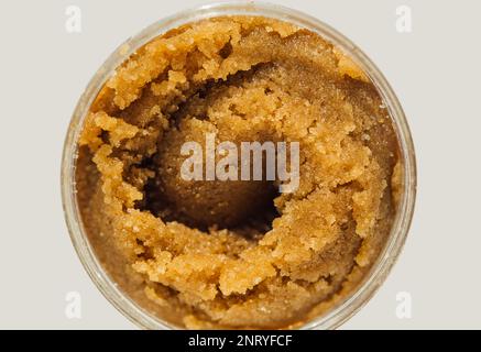 Consistenza dello scrub di zucchero di canna fatto a mano in un vaso rotondo Foto Stock