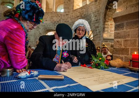 Nijmegen, Paesi Bassi. 21st Feb, 2023. Lo sposo si vede firmare il falso certificato di matrimonio. La tradizione del falso matrimonio contadino durante il carnevale risale al XVI secolo, la nobiltà giocava il ruolo dei contadini e i contadini erano i signori. A Nijmegen, Anja e Theo Wijlemans sono state la coppia di nozze del contadino, quest'anno. La coppia si è riunita nella cappella di Valkhof, indossando abiti tradizionali contadini e circondata da persone che indossavano costumi vivaci. Il matrimonio del contadino è una delle tradizioni del Carnevale Olandese, specialmente nel Limburgo, nel Brabante del Nord e nel Gelderland. Foto Stock